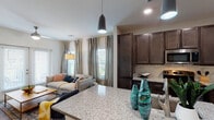 This single-story residence in Mary Esther, Florida offers a carefully designed layout that maximizes both functionality and comfort. The open-concept kitchen and living area serves as the heart of the home, where rich dark espresso cabinetry, granite countertops, a marble-style tile backsplash, and stainless steel appliances — including a range, microwave, and refrigerator — create a polished and practical culinary space. A peninsula counter extends the workspace and provides a natural connection to the living area. The living room is bright and inviting, featuring luxury vinyl plank flooring, a ceiling fan, and French doors that allow natural light to pour in. The bedroom is a comfortable retreat with plush carpeting, multiple windows, a ceiling fan, and direct access to a walk-in closet. The full bathroom includes a tub-shower combination, granite vanity, wood-tone cabinetry, and clean white finishes. An entryway nook with built-in shelving and bench seating adds a functional mudroom-style touch. Recessed lighting and neutral wall tones carry throughout, creating a cohesive and modern aesthetic well-suited to everyday living in the Florida Panhandle.