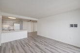 Located at 1207 S El Camino Real in Oceanside, California, this two-bedroom, two-bathroom residence offers a well-organized single-level layout with a clean, modern aesthetic throughout. Light wood-style flooring flows consistently across the living areas and bedrooms, creating a bright and cohesive feel.

The open-concept kitchen is a standout feature, showcasing gray shaker cabinetry, a striking quartz peninsula with a waterfall-style countertop and undermount sink, and white appliances including a range and refrigerator. The peninsula connects seamlessly to the dining and living areas, making it ideal for both daily living and entertaining.

The living room is bright and airy, with a sliding glass door that opens to a private balcony offering scenic outdoor views of the surrounding Oceanside landscape, filling the space with natural light.

Both bedrooms are comfortably sized, each featuring windows with outdoor views and generous closet space — with five closets distributed throughout the unit. The primary bedroom is notably spacious and well-appointed.

The two bathrooms are finished with gray shaker vanities, quartz countertops, mirrored medicine cabinets, and light wood-style flooring, maintaining the consistent modern style found throughout the home.