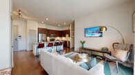 This single-floor residence offers a thoughtfully designed open-concept layout that seamlessly connects the living, dining, and kitchen areas. Rich hardwood-style flooring runs throughout the main living space, complementing the warm tones of the dark espresso cabinetry in the kitchen. The kitchen is well-appointed with stainless steel appliances, including a refrigerator, range, and built-in microwave, alongside granite countertops and a stone tile backsplash. A peninsula with bar seating provides an ideal spot for casual dining and entertaining.

The living area is bright and inviting, with recessed lighting and access to an outdoor space through sliding glass doors dressed with sheer curtains, allowing natural light to filter in. The bedrooms are carpeted and generously sized, each featuring large windows with blinds that offer a soft, airy atmosphere.

The bathroom is finished with large-format tile flooring, dark cabinetry with granite countertops, and a wide vanity mirror, reflecting a consistent attention to detail found throughout the residence. Overall, the space presents a clean, contemporary aesthetic with quality finishes at every turn.