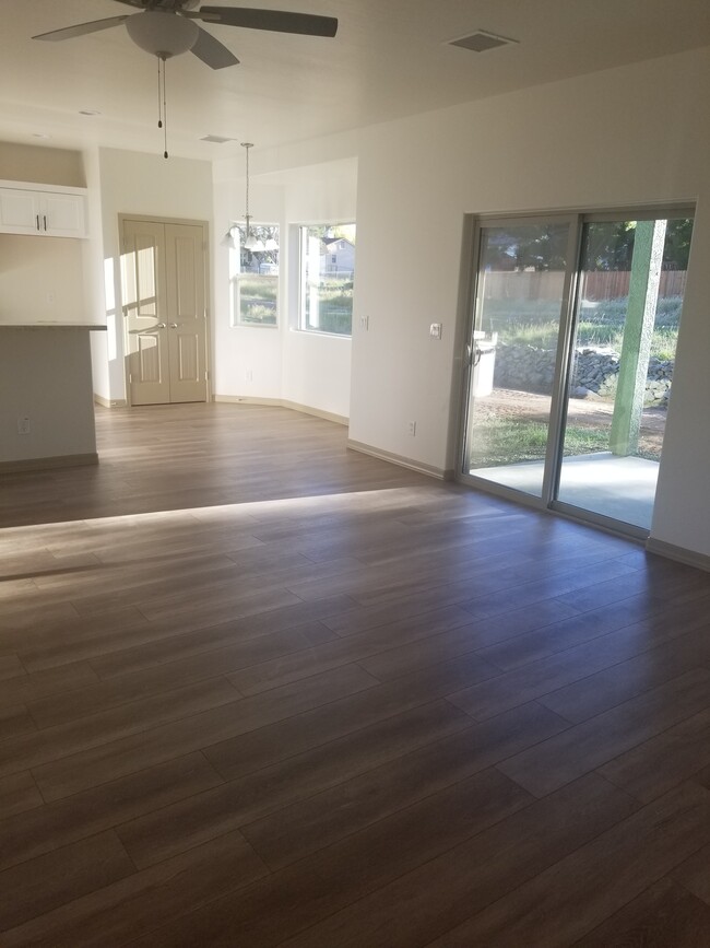 Spacious living room with waterproof laminate flooring and a slider overlooking the yard - 5180 N Roadrunner Dr