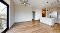 Located in Lone Tree, CO, this modern 2-bedroom, 2-bathroom residence offers a thoughtfully designed single-floor layout with contemporary finishes throughout. Light wood-tone flooring runs seamlessly across the entire space, creating a warm and cohesive aesthetic.

The open-concept living area is a standout feature, anchored by expansive floor-to-ceiling windows and a glass door leading to a private balcony. The elevated position affords sweeping views of the surrounding Lone Tree landscape, and a ceiling fan adds both style and comfort to the bright, airy room.

The kitchen is well-appointed with light wood cabinetry, white quartz countertops, a subway tile backsplash, stainless steel appliances including a French door refrigerator, electric range, microwave, and dishwasher, plus a central island with pendant lighting above for additional prep and gathering space.

Both bedrooms are comfortably sized, each featuring large windows with urban views and ceiling fans. The primary bedroom includes generous closet space. The en-suite primary bathroom offers a dual-sink vanity with quartz countertops and a walk-in tile shower, while the second bathroom features a soaking tub and shower combo. Three closets total provide ample storage throughout the residence.