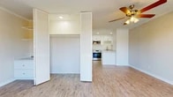 Located at 10 Nautical Mile Dr in Newport Beach, CA, this efficiently designed single-floor unit offers a well-appointed layout comprising a bedroom, kitchen, and balcony. Light-toned hardwood-style flooring runs throughout, creating a cohesive and clean aesthetic across all areas of the space.

The main living area is bright and open, featuring a ceiling fan with light fixture and a large sliding glass door dressed with vertical blinds that invites natural light while providing access to the balcony. Crown molding adds a refined architectural detail to the room.

The kitchen is thoughtfully outfitted with white shaker-style cabinetry, stone-look countertops, and a full suite of stainless steel appliances including a range, over-the-range microwave, and refrigerator. A peninsula counter extends the workspace and serves as a visual divider between the kitchen and the living area. Recessed lighting illuminates the kitchen efficiently.

The bedroom is a cozy, functional space with warm neutral walls and access to a closet with louvered bifold doors, providing ample storage. The overall design of the unit is clean and contemporary, with a neutral color palette throughout that contributes to a bright and airy atmosphere — well-suited to the coastal Newport Beach setting.