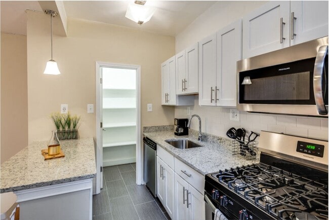 Renovated kitchen with stainless steel appliances and granite countertops - Kew Gardens Apartments