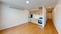 Located in Seattle's Fremont neighborhood, this one-bedroom, one-bathroom unit offers a thoughtfully designed layout that maximizes every square foot. The open-plan kitchen and living area forms the heart of the space, featuring warm wood-toned cabinetry, a full suite of stainless steel appliances including an electric range and refrigerator, recessed lighting, and light hardwood-style flooring that adds warmth and continuity throughout. A dedicated entrance and hallway lead efficiently to each area of the unit. The bedroom is carpeted for comfort and includes two closets, providing ample storage for a space of this size. The combined bathroom and laundry room is clean and modern, finished with light hardwood-style flooring, a wood-grain vanity with white countertop, a full shower, and a stacked in-unit washer and dryer — a highly practical feature. Crisp white walls throughout give the unit a bright, clean aesthetic, while the efficient floor plan ensures every room serves a clear purpose. This unit is well-suited for those seeking a functional, modern living space in one of Seattle's most vibrant and walkable neighborhoods.