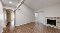 Located in Austin, TX 78759, this 2-bedroom, 3-bathroom single-story residence offers a well-planned layout designed for comfortable everyday living. Wood-look flooring runs consistently throughout the home, creating a cohesive and easy-to-maintain aesthetic.

The open living and dining area is an immediate highlight, featuring dramatic vaulted ceilings with exposed beams that lend a sense of spaciousness well beyond its footprint. A brick fireplace anchors one end of the room, while a sliding glass door fitted with vertical blinds opens to a private patio and allows generous natural light to fill the space. The entry foyer transitions seamlessly into this main living area.

The kitchen is equipped with stainless steel appliances, including a range and built-in microwave, complemented by gray cabinetry and light speckled countertops. It connects conveniently to the dining area for easy flow during meals.

Both bedrooms are comfortably sized, each featuring ceiling fans with light fixtures and windows with blinds. The primary bedroom benefits from an expansive walk-in closet with dual clothing rods, offering abundant storage. The second bedroom includes a wide bifold-door closet. With four closets total throughout the home, storage is plentiful. The three bathrooms are finished in a clean, neutral palette with updated vanities and full tub-shower combinations.