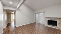 Located in Austin, TX 78759, this 2-bedroom, 3-bathroom single-story residence offers a well-planned layout designed for comfortable everyday living. Wood-look flooring runs consistently throughout the home, creating a cohesive and easy-to-maintain aesthetic.

The open living and dining area is an immediate highlight, featuring dramatic vaulted ceilings with exposed beams that lend a sense of spaciousness well beyond its footprint. A brick fireplace anchors one end of the room, while a sliding glass door fitted with vertical blinds opens to a private patio and allows generous natural light to fill the space. The entry foyer transitions seamlessly into this main living area.

The kitchen is equipped with stainless steel appliances, including a range and built-in microwave, complemented by gray cabinetry and light speckled countertops. It connects conveniently to the dining area for easy flow during meals.

Both bedrooms are comfortably sized, each featuring ceiling fans with light fixtures and windows with blinds. The primary bedroom benefits from an expansive walk-in closet with dual clothing rods, offering abundant storage. The second bedroom includes a wide bifold-door closet. With four closets total throughout the home, storage is plentiful. The three bathrooms are finished in a clean, neutral palette with updated vanities and full tub-shower combinations.