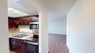 This 860 square foot apartment offers a well-designed living space with two bedrooms and one bathroom. The open-concept layout maximizes the use of space, creating a seamless flow between the living room and kitchen areas. The primary bedroom, measuring 160 square feet, provides a comfortable retreat.

The kitchen is a standout feature, boasting rich cherry wood cabinetry, stainless steel appliances, and a neutral-toned countertop and backsplash. The living area is bright and airy, with large sliding glass doors that allow natural light to flood the space.

Both bedrooms feature warm wood flooring and ceiling fans, enhancing comfort and air circulation. The apartment includes ample storage solutions, with built-in closets in the bedrooms and additional shelving in the laundry area.

The bathroom, while compact, is efficiently designed with a modern vanity and fixtures. Throughout the apartment, the neutral color palette and consistent flooring create a cohesive and inviting atmosphere. The unit also includes in-unit laundry facilities, adding to its convenience and livability.