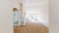Located at 700 W Belleview Ave in Littleton, CO, this one-bedroom, one-bathroom residence offers a well-designed layout with a range of notable architectural features. The living area immediately impresses with soaring vaulted ceilings that amplify the sense of openness and allow natural light to flood the space through a sliding glass door leading to a private balcony. A tile-surround fireplace serves as a central focal point, elegantly dividing the living area from the kitchen while adding warmth and character. Decorative arched niches and doorways throughout lend a charming architectural detail to the neutral-toned interior. The kitchen features light wood cabinetry, a peninsula breakfast bar, tile flooring, and a white appliance suite, seamlessly connecting to the main living space. A gold pendant chandelier adds a classic touch above the dining area. The carpeted bedroom is generously proportioned with access to two closets and a full bathroom. The bathroom includes a tiled soaking tub and shower combination. Additional spaces include a utility room, hallway, and ample storage. Abundant natural light and a cohesive neutral palette create a bright, welcoming ambiance throughout.