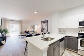 Located at 4601 S Balsam Way in Littleton, CO, this well-appointed 2-bedroom, 2-bathroom residence offers a thoughtfully designed single-level layout. The open-concept kitchen and living area serves as the heart of the home, featuring a large peninsula with a stainless steel sink and white quartz countertops, two-tone cabinetry with gray lower cabinets and white uppers, a classic subway tile backsplash, and stainless steel appliances including a range, microwave, and refrigerator. The living room is bright and airy, with light wood-style flooring, neutral walls, and sliding glass doors that invite natural light and provide direct access to an outdoor patio. Both bathrooms are finished with gray vanity cabinetry, white quartz countertops, and wood-style flooring, with one featuring a shower-tub combination. The bedrooms are carpeted for comfort, with the primary bedroom offering a spacious walk-in closet and a charming built-in arched desk nook — ideal for a home office. A connecting hallway and two dedicated closets round out the functional layout. The overall ambiance is clean, contemporary, and move-in ready.