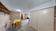 Located at 829 Tappan St in Ann Arbor, MI, this single-floor, 2-bedroom, 2-bathroom unit offers a functional and straightforward layout. A defining architectural feature throughout the space is the exposed brick accent walls, which add texture and character to the living and dining areas. The combined living and dining room is carpeted and open in feel, with large sliding glass doors fitted with vertical blinds that allow natural light to fill the space and provide outdoor views. Built-in shelving on the brick wall adds a practical display element. The kitchen is positioned just off the dining area and is accessible through a wood-paneled door. Each bedroom is carpeted and offers closet space. The primary bedroom is generously proportioned, featuring a large window with vertical blinds, a wall-mounted HVAC unit, and ample room for furnishings. The second bedroom also features an exposed brick wall and a mirrored closet. Three closets throughout the unit provide additional storage. Both bathrooms are well-appointed, with one featuring a dark-vanity cabinet, white countertop, dual mirrors, and a tiled tub-shower combination. A hallway connects the main living areas to the bedrooms and bathrooms, completing this efficiently designed unit.