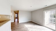 Located at 2352 Township Road in Charlotte, NC, this well-appointed 3-bedroom, 2-bathroom single-floor home offers a thoughtfully designed layout across a comfortable footprint. Light-toned wood-look flooring flows throughout the main living areas, complementing neutral gray walls and textured ceilings that give each room a clean, modern feel.

The living room receives abundant natural light and features sliding glass doors that open directly onto a private balcony with white railings and outdoor views. A pass-through window connects the living area to the kitchen, which is outfitted with white shaker cabinetry, granite-patterned countertops, stainless steel appliances including a refrigerator and range, and a pendant chandelier that adds a polished touch. The adjacent dining area is visible from the kitchen, creating an open, connected feel.

Each of the three bedrooms is bright and well-proportioned, featuring natural light from windows with blinds, light wood-look flooring, and closet access. The primary bedroom offers a generous layout. Both bathrooms are finished with granite countertops, white cabinetry, and elegant vanity lighting. Additional features include multiple closets, a dedicated laundry area, and a utility room, providing ample storage and functionality throughout the home.