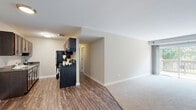 Located at 16W472 Honeysuckle Rose Ln in Willowbrook, IL, this single-floor, 4-bedroom, 1-bathroom home offers a thoughtfully arranged layout with a neutral color palette and a blend of hardwood-style and carpet flooring throughout. The living room is a bright and open space, anchored by a large sliding glass door that fills the room with natural light and provides direct access to a private outdoor deck overlooking lush greenery. The galley-style kitchen is well-appointed with rich dark wood cabinetry, granite-look countertops, a stainless steel sink, and black appliances including a refrigerator and gas range, all set atop durable wood-look flooring. The four bedrooms are comfortably sized, carpeted for warmth and comfort, and feature neutral walls with white trim. Several bedrooms benefit from windows with vertical blinds that allow for natural light and outdoor views. The shared full bathroom is clean and functional, featuring a tub/shower combination with white tile surround, a dark wood vanity with a white sink, a large mirror, and wood-look flooring. A closet provides additional storage. The overall ambiance is clean, practical, and move-in ready.