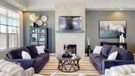 This single-floor community clubhouse offers a thoughtfully designed layout that blends comfort and functionality. The centerpiece of the space is an inviting lounge area anchored by a striking floor-to-ceiling white subway tile fireplace wall, complete with a mounted flat-screen TV and a slate-gray mantel. Deep navy sofas, a geometric wood coffee table, and a patterned area rug create a warm, contemporary gathering atmosphere, while natural light filters in through large windows offering neighborhood views.

The well-equipped fitness center is a standout amenity, featuring a wide array of cardio machines including ellipticals, treadmills, and stationary bikes, along with cable machines, free weights, and wall-mounted mirrors. Ceiling fans and large windows keep the space bright and airy. A dedicated cardio room provides additional workout options.

The modern kitchen showcases rich dark cabinetry, granite countertops, stainless steel appliances, light hardwood-style flooring, and pendant lighting — ideal for community events. An adjacent dining nook with large windows offers a bright, casual space for gathering.

The entry corridor features light tile flooring, stacked stone accent columns, and glass-panel doors, creating a welcoming transition into the space. Hallways connecting the amenity areas are clean and well-lit, completing this polished community facility.