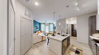 Located at 1559 W Nine Mile Rd in Pensacola, Florida, this single-story residence offers a thoughtfully designed open-concept floor plan that seamlessly connects the kitchen, dining, and living areas. The kitchen is a standout feature, boasting a large center island with a quartz countertop and undermount sink, two-tone cabinetry pairing crisp white upper cabinets with rich dark lower cabinets, stainless steel appliances, and stylish pendant lighting complemented by a track lighting system. Light wood-tone flooring flows throughout the main living areas, enhancing the bright and airy atmosphere. The living room makes a bold design statement with a striking teal patterned accent wall, ceiling fan, and access to a private exterior door that invites natural light. The bedroom is well-proportioned, featuring a ceiling fan, a window with exterior views, and light wood flooring. The bathroom is finished with a quartz vanity top, dark wood-tone cabinetry, a framed mirror, and a glass-enclosed shower. Throughout the space, clean lines, neutral tones, and modern fixtures combine to create a cohesive, contemporary aesthetic that is both functional and visually engaging.