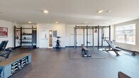 This state-of-the-art gym, located at 6640 N Towne Rd in Windsor, WI, offers a comprehensive fitness experience within its 1190 square feet of space. The facility is thoughtfully designed with distinct zones to accommodate various workout styles. Large windows line the walls, flooding the space with natural light and providing views of the surrounding area.

The cardio section boasts a row of modern treadmills and elliptical machines, perfect for endurance training. Adjacent to this, a dedicated area houses stationary bikes and other cardio equipment. For strength training enthusiasts, the gym features a well-stocked free weights section with dumbbells, benches, and a multi-functional power rack.

The facility's layout promotes easy navigation and efficient use of space. High ceilings contribute to an open, airy atmosphere, while recessed lighting ensures even illumination throughout. The flooring is a durable, non-slip material suitable for high-impact activities.

Additional amenities include a stretching area with exercise balls and mats, as well as accessory equipment like resistance bands and medicine balls. The gym's modern design, coupled with its comprehensive range of equipment, creates an inviting environment suitable for fitness enthusiasts of all levels.