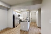 Located at 10571 Colorado Blvd in Thornton, Colorado, this single-floor, 2-bedroom, 2-bathroom home offers a thoughtfully designed layout with modern finishes throughout. Light wood-tone vinyl plank flooring flows seamlessly through the entire space, creating a clean and cohesive aesthetic.

The open-concept kitchen, dining, and living area serves as the heart of the home. The kitchen is equipped with white shaker-style cabinetry, dark granite countertops, stainless steel appliances including a refrigerator, microwave, and dishwasher, and a central island with a built-in sink — ideal for both cooking and entertaining. The living area extends to a sliding glass door that opens to an outdoor space, with an adjacent window allowing ample natural light.

Both bedrooms are generously proportioned, each featuring ceiling fans and easy access to closet space. The primary bedroom connects to its own bathroom and benefits from natural light through a large window. The second bedroom is equally well-sized with its own closet access. The bathrooms are finished with white subway tile surrounds and black hardware accents for a contemporary touch.

Additional highlights include multiple closets offering exceptional storage, a dedicated laundry area, a utility room, and connecting hallways that keep the floor plan organized and efficient.