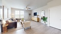 Located in Bettendorf, Iowa, this thoughtfully designed 2-bedroom, 2-bathroom residence delivers a comfortable and modern living experience across a single, efficiently laid-out floor. Light wood-style flooring flows throughout the main living areas, complementing a neutral color palette that creates a bright and welcoming atmosphere.

The open living room is a central highlight, featuring a ceiling fan, large windows that invite ample natural light, and views of the surrounding greenery and open landscape. The kitchen is well-appointed with white shaker-style cabinetry, light stone-look countertops, a stainless steel sink, and black appliances including a range and over-the-range microwave.

A central hallway connects both bedrooms with ease. The primary bedroom is generously sized with plush carpeting, and the second bedroom also features carpet flooring and large windows overlooking open fields. Both bathrooms are finished with wood-style flooring, white cabinetry with stone-look countertops, and full tub-shower combinations. A dedicated closet provides additional storage.

The exterior surroundings feature expansive green lawns, open skies, and a fenced area, offering residents a peaceful, spacious environment in a quiet Bettendorf community.