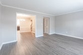 Located at 2112 Criston Dr in Newport News, Virginia, this two-story home offers a well-designed layout with thoughtful finishes throughout. The main level features durable hardwood-style flooring that flows through the living and dining areas. The dining room is appointed with crown molding, chair rail detail, neutral grey walls, and an elegant brushed nickel chandelier, creating a refined yet welcoming atmosphere. The adjacent living room benefits from natural light streaming through French doors that open to the exterior, enhancing the sense of openness. The kitchen is well-equipped with dark cabinetry, granite-style countertops, stainless steel appliances including a range, microwave, and refrigerator, and a window above the sink that brings in additional natural light. The bathrooms feature clean white tile tub-and-shower combinations with chrome fixtures, providing a bright and functional space. The bedrooms are carpeted for comfort and include ceiling fans with light fixtures and generous closet space — the primary bedroom notably offers dual closets. Each bedroom receives natural light through windows with blinds. The home's neutral color palette and updated finishes make it a move-in ready residence in an established Newport News neighborhood.