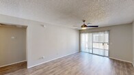 Located at 7021 West McDowell Road in Phoenix, Arizona, this single-floor residence offers a thoughtfully designed layout with one bedroom and two bathrooms. Throughout the home, wood-style laminate flooring provides a clean, modern foundation that ties each room together cohesively.

The living room is a generous, open space highlighted by a ceiling fan with light fixture and a full-width sliding glass door fitted with vertical blinds, opening to a private outdoor balcony that invites natural light deep into the interior.

The galley-style kitchen is efficiently arranged with white cabinetry, light stone-look countertops, a stainless steel sink, and a full suite of appliances including a refrigerator, electric range, and microwave. Track lighting overhead keeps the space bright and functional.

The spacious primary bedroom features a textured ceiling, ample room to furnish comfortably, and access to a large walk-in closet with built-in shelving. A dining or flex area adjacent to the kitchen includes open built-in shelving and an elegant chandelier, adding versatility to the floor plan.

Both bathrooms are finished in a clean, neutral palette. One features a wide vanity with a large mirror, while the other includes a full tub-shower combination. Wood-look tile flooring carries through both bathrooms, maintaining a consistent aesthetic throughout the home.