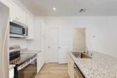 This well-appointed two-story home in Gainesville, FL offers three bedrooms and four bathrooms across two thoughtfully designed floors. The main level features an open-concept layout that seamlessly connects the living room, dining area, and kitchen. The kitchen is a standout, boasting white shaker cabinetry, granite countertops, a central island with a sink, and a full suite of stainless steel appliances, including a refrigerator, range, microwave, and dishwasher. Light wood-style flooring flows throughout the home, complementing the bright, white walls and creating a clean, modern aesthetic. Natural light enters through windows dressed with white blinds, enhancing the airy feel of each room. The bathrooms are consistently finished with granite-topped vanities, white cabinetry, and tub-shower combinations. Each bedroom is generously proportioned, with the primary suite offering a walk-in closet equipped with wire shelving. Additional highlights include a dedicated laundry area, multiple utility spaces, and ample closet storage across both floors. The staircase connects the two levels efficiently, and the overall layout is practical and functional, making this home an excellent fit for everyday living.