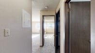 Located at 2300 E 18th St in Casper, Wyoming, this one-bedroom, one-bathroom unit offers a practical and well-organized single-floor layout. The living area features plush carpeting, textured ceilings, and natural light streaming through a window, creating a warm and inviting atmosphere. A half-wall pass-through connects the living space to the kitchen, enhancing the open feel between the two areas. The kitchen is equipped with warm oak cabinetry offering ample storage, white appliances including a coil-top electric range and dishwasher, a double basin sink, and light-colored countertops, all set on tile flooring. The bedroom is a comfortable, well-proportioned room with soft carpeting, baseboard heating, a wall-unit air conditioner, and a window that frames views of the surrounding landscape. A dedicated closet provides convenient storage. The bathroom features tile flooring, a full tub-shower combination with a white surround, a vanity with a mirrored medicine cabinet, and overhead lighting. A carpeted hallway connects the rooms, providing a cohesive flow throughout the unit. This home offers a straightforward, functional living environment well-suited for Casper's climate.