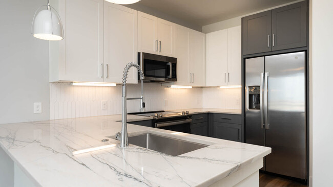 Kitchen with Marble Countertops and Stainless Steel Appliances - Olivian at the Realm