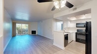 Located at 4610 Fulton Ave in Sherman Oaks, Los Angeles, this 2-bedroom, 2-bathroom single-floor home offers a well-designed open layout that maximizes its comfortable living space. The combined living and kitchen area serves as the heart of the home, featuring light hardwood-style flooring that flows throughout. The living room is highlighted by a classic fireplace, a ceiling fan, and a sliding glass door that opens to a private balcony, filling the space with natural light and outdoor greenery views. The kitchen is outfitted with crisp white cabinetry, light stone countertops, a peninsula with a sink, a tray ceiling with track lighting, and a full suite of black appliances including a gas range, microwave, dishwasher, and refrigerator. The spacious primary bedroom offers a generous footprint, a large window with lush outdoor views, and a mirrored sliding closet door. The second bedroom is well-proportioned with neutral walls and ample natural light. Both bathrooms feature clean white finishes with tub-shower combinations and large vanity mirrors. Throughout the home, neutral tones, clean lines, and consistent flooring create a cohesive and move-in-ready aesthetic.