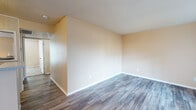 This single-floor residence offers a well-organized layout designed for comfortable everyday living. The main living area features durable wood-look plank flooring and warm neutral-toned walls, creating a bright and welcoming atmosphere. A large sliding glass door fitted with vertical blinds floods the space with natural light while providing direct access to an outdoor patio, offering pleasant views of the surrounding exterior. Adjacent to the living area, a dedicated dining space is accented by a classic chandelier and a window with horizontal blinds, making it an ideal setting for meals and gatherings. The galley-style kitchen is efficiently designed with white cabinetry, laminate countertops, a stainless steel sink, and black appliances including a refrigerator and electric range, complemented by a dishwasher and ample overhead storage. The bedrooms are carpeted for added comfort and each features a ceiling fan with light fixture, a window for natural light, and closet access. The bathrooms are thoughtfully appointed, with one featuring a wide vanity with white cabinetry, a large mirror, and a light bar, while another offers a full toilet and additional built-in storage. Textured ceilings are consistent throughout the space, adding a classic finishing touch to each room.