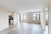 Located at 2701 Calvert St NW in Washington, DC's desirable Woodley Park neighborhood, this well-appointed two-bedroom, two-bathroom residence offers a clean, modern aesthetic throughout its thoughtfully designed single-floor layout. Light-toned hardwood-style flooring runs continuously throughout the home, complementing the neutral warm-white walls and creating a cohesive, airy feel.

The open-plan combined living and dining area serves as the heart of the home, bathed in natural light through large windows that frame outdoor views. A glass door leads directly to a private balcony, extending the living space outdoors. The kitchen sits adjacent to the living area and features stainless steel appliances, white cabinetry, and a tile backsplash.

The spacious primary bedroom offers generous proportions, abundant natural light via multiple windows, and dedicated closet space. The second bedroom is equally well-lit, with a large window and light-filled interior. Both bathrooms are finished in neutral tones, with the full bath featuring a tiled tub-shower combination and granite-accented vanity.

Additional highlights include two hallways with built-in closet storage, a dedicated in-unit laundry area, and a practical layout that maximizes every square foot. The overall ambiance is clean, bright, and move-in ready.