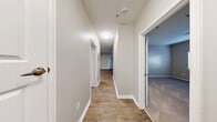 Located at 8001 E 11th Ave in Denver, CO, this well-appointed two-bedroom, two-bathroom residence offers a thoughtfully designed single-level layout with a comfortable sense of space throughout. The open-concept kitchen and living area serves as the heart of the home, featuring rich dark hardwood-style flooring, a tile-surround corner fireplace, and sliding glass doors that lead to a private balcony, filling the space with natural light. The kitchen is equipped with stainless steel appliances — including a refrigerator, range, microwave, and dishwasher — white shaker cabinetry, white quartz countertops, and a striking black hexagonal tile backsplash that adds a bold design touch. Both bathrooms are finished with white vanities, quartz countertops, large mirrors, and modern brushed nickel fixtures and lighting. The bedrooms are carpeted for comfort, with the primary bedroom offering generous proportions, access to a closet, and a bright window view. A dedicated in-unit laundry room houses a full-size washer and dryer. Four closets provide ample storage throughout. The neutral warm-gray color palette and clean finishes create a cohesive, move-in-ready ambiance across the entire residence.