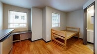This 130 square foot office space, located at 4742 20th Ave NE in Seattle, offers a compact yet functional environment for professional work. The single-floor layout maximizes the use of available space, featuring one main office area and a private bathroom.

The office area boasts warm hardwood flooring, creating an inviting atmosphere. Large windows allow ample natural light to flood the space, enhancing the work environment. The room is equipped with a built-in desk area, perfect for computer work or writing tasks. A lofted bed frame provides a clever space-saving solution, potentially allowing for short rest periods or additional storage.

The kitchenette area includes a microwave and mini-fridge, offering convenience for light meal preparation. A small dining or meeting table is also present, suitable for quick lunches or small collaborative sessions.

The bathroom, while compact, is efficiently designed with modern fixtures including a toilet and vanity. The neutral color palette throughout the space maintains a professional appearance.

Mirrored closet doors expand the visual space and provide storage options. The office's layout, despite its small footprint, demonstrates thoughtful design to maximize functionality in a limited area, making it an ideal solution for solo professionals or small startups in the heart of Seattle.