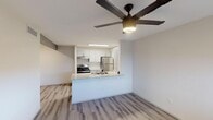 Located at 1350 E Northern Ave in Phoenix, Arizona, this single-floor residence offers a clean, modern aesthetic throughout its well-designed layout. The open-concept living and kitchen area serves as the heart of the home, where light wood-style plank flooring extends across the space, complemented by a contemporary ceiling fan with integrated lighting. A peninsula with granite-look countertops connects the kitchen to the living area, providing both additional workspace and a natural gathering point. The kitchen is equipped with stainless steel appliances, including a refrigerator and range, beneath bright flush-mount lighting. White cabinetry with sleek hardware and a range hood complete the functional and stylish cooking space. The living area benefits from a window that brings in natural light, creating a bright and welcoming atmosphere. The bedrooms are finished with plush carpet flooring and feature windows fitted with blinds for privacy and light control. The bathroom area includes a modern vanity with granite-look countertops, updated cabinetry in a soft gray finish, and well-lit mirrors. Adjacent to the vanity, a walk-in closet with built-in shelving provides ample storage. The overall design presents a neutral, contemporary palette throughout, offering a move-in ready living environment in the heart of Phoenix.