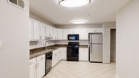 Located in Brookhaven, GA, this single-floor residence offers a practical and well-appointed layout designed for comfortable everyday living. The living area features light wood-look flooring, neutral gray walls, and a louvered closet, flowing seamlessly into the kitchen through an open-concept passage. Natural light enters through window-fitted rooms, enhancing the bright, clean aesthetic throughout.

The kitchen is a standout feature, outfitted with crisp white cabinetry, dark granite countertops, a white subway tile backsplash, and light ceramic tile flooring. It includes a full suite of black and stainless steel appliances — a refrigerator, electric range, over-the-range microwave, and dishwasher — along with a stainless steel sink, providing ample functionality and storage.

The bedroom is carpeted for comfort and receives natural light through a window with blinds. The bathroom is bright and clean, featuring a dual-sink vanity with white cabinetry, a large mirror, white tile flooring, and a glass-enclosed shower. A dedicated laundry area accommodates a full-size washer and dryer alongside a water heater. The entry area offers wood-look flooring and a window beside the front door, creating a welcoming arrival experience.