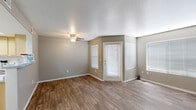 This single-floor unit offers a thoughtfully designed layout with a clean, neutral aesthetic that carries throughout every room. The open living area is a welcoming space, featuring warm wood-look vinyl plank flooring, soft taupe walls, and crisp white baseboards. Multiple windows fitted with horizontal blinds allow abundant natural light to fill the room, while a ceiling fan with a light fixture provides both comfort and illumination. A paneled front door provides a secure and polished entry point into the space.

The kitchen is efficiently laid out, maximizing functionality with light wood cabinetry that extends to the ceiling for ample storage. Speckled light countertops provide generous prep space, complemented by a double-basin stainless steel sink. White appliances — including a refrigerator, electric range, over-the-range microwave, and dishwasher — complete the well-equipped kitchen. The same wood-look flooring continues seamlessly from the living area into the kitchen.

The bedroom offers a cozy retreat with plush neutral carpeting and a window that invites natural light. The room provides a calm and quiet atmosphere, well-suited for rest.

The bathroom is clean and functional, featuring a light wood vanity with a speckled countertop, a large mirror with an overhead vanity light bar, and a standard white toilet, creating a bright and tidy finish.
