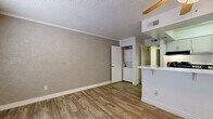 Located in Glendale, Arizona, this two-bedroom, one-bathroom unit offers a practical and efficient single-floor layout. The living area features wood-look plank flooring, textured walls, and a textured ceiling, creating a warm and understated ambiance. A half-wall pass-through connects the living space to the kitchen, which is outfitted with gray cabinetry, a light quartz-style countertop, black appliances including an electric range and refrigerator, and an overhead exhaust vent. The kitchen's clean, functional design maximizes the use of available space. A convenient in-unit stacked washer and dryer is tucked into a dedicated closet off the main living area, adding everyday practicality. Both bedrooms are carpeted and feature textured walls, with windows that allow natural light to filter in. The primary bedroom includes a closet and direct visual access to the full bathroom, which is outfitted with a shower-tub combination, toilet, and vanity with storage. A hallway linen closet provides additional storage between the bedrooms and bathroom. Wood-look flooring continues through the hallway, tying the common areas together cohesively. This well-organized unit delivers essential amenities in a compact, easy-to-navigate floor plan.