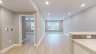 135 Stevens Ave is a thoughtfully designed single-floor residence that combines contemporary finishes with a clean, open layout. Light hardwood flooring runs throughout the main living areas, complementing the soft neutral gray walls and crisp white trim that give the space a bright, cohesive feel. The open-concept living and dining area is bathed in natural light from large windows, while recessed lighting overhead ensures the space remains well-lit at all hours. A ceiling fan adds comfort to the adjacent room, which also enjoys outdoor views through its own window.

The kitchen is a standout feature, outfitted with white shaker cabinetry, gray subway tile backsplash, and sleek quartz countertops extending to a peninsula with pendant lighting above. Stainless steel appliances — including a gas range, microwave, and refrigerator — complete the modern setup, with a matte black faucet adding a sharp design contrast.

The bedrooms offer generous proportions with the same light hardwood floors, neutral tones, and ample natural light. Each room is equipped with ceiling fans and well-placed outlets for functionality.

The bathroom presents a bold contrast with dark tile flooring, a white vanity topped with a black granite countertop, a large mirror, matte black fixtures, and a full tub-shower combination framed by classic white tile — creating an elegant, modern aesthetic throughout.