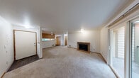 Located in University Place, Washington, this single-floor, three-bedroom, two-bathroom home offers a practical and comfortable layout. The living room serves as the heart of the home, highlighted by a classic brick fireplace and a sliding glass door that opens to a private balcony with views of mature greenery. Plush carpeting runs throughout the living and bedroom areas, adding warmth underfoot.

The kitchen is efficiently designed in a galley style, featuring warm oak cabinetry, white countertops, hardwood-style flooring, and white appliances including a dishwasher and electric range. A pass-through counter connects the kitchen to the adjacent living space, enhancing the open feel. A window above the sink allows natural light to brighten the workspace.

All three bedrooms are carpeted and feature windows fitted with blinds, providing natural light and views of the surrounding neighborhood and tree-lined scenery. The primary bedroom offers a generous footprint with ample wall space. The two bathrooms are straightforward and functional, each equipped with a full tub-shower combination with chrome fixtures and neutral-toned surrounds. This home presents a clean, move-in ready layout well-suited for those seeking comfortable living in University Place.