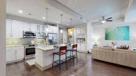 Located in the heart of Midtown Atlanta, this well-appointed residence at 782 Peachtree St NE offers a thoughtfully designed single-floor layout with an open-concept living, dining, and kitchen area. Rich hardwood flooring flows throughout the main living spaces, grounding the bright, neutral palette of the interior.

The gourmet kitchen is a standout feature, showcasing white shaker cabinetry, light granite countertops, a subway tile backsplash, stainless steel appliances — including a French door refrigerator, range, and microwave — and a central island with pendant lighting and bar seating. A dedicated built-in wine rack and in-unit washer/dryer add notable convenience.

The living area is anchored by large sliding glass doors that open to a private balcony, offering views of the surrounding Midtown skyline and abundant natural light. A ceiling fan completes the comfortable ambiance of the main living space.

The primary bathroom is generously proportioned, featuring a double-sink vanity with granite countertops, white cabinetry, large-format tile flooring, and a soaking tub with tile surround. The bedroom offers a quiet, carpeted retreat with ample space. A private balcony accessible from the living area provides an ideal outdoor escape within the urban landscape.