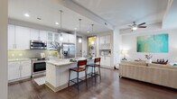 Located in the heart of Midtown Atlanta, this well-appointed residence at 782 Peachtree St NE offers a thoughtfully designed single-floor layout with an open-concept living, dining, and kitchen area. Rich hardwood flooring flows throughout the main living spaces, grounding the bright, neutral palette of the interior.

The gourmet kitchen is a standout feature, showcasing white shaker cabinetry, light granite countertops, a subway tile backsplash, stainless steel appliances — including a French door refrigerator, range, and microwave — and a central island with pendant lighting and bar seating. A dedicated built-in wine rack and in-unit washer/dryer add notable convenience.

The living area is anchored by large sliding glass doors that open to a private balcony, offering views of the surrounding Midtown skyline and abundant natural light. A ceiling fan completes the comfortable ambiance of the main living space.

The primary bathroom is generously proportioned, featuring a double-sink vanity with granite countertops, white cabinetry, large-format tile flooring, and a soaking tub with tile surround. The bedroom offers a quiet, carpeted retreat with ample space. A private balcony accessible from the living area provides an ideal outdoor escape within the urban landscape.