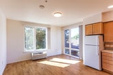 Located at 1701 W El Camino Real in Mountain View, CA, this efficiently designed single-floor unit makes smart use of its compact footprint. The interior features consistent light wood laminate flooring throughout, crisp white walls, and flush-mounted ceiling lighting that together create a bright, clean atmosphere.

The living room is a welcoming, sun-filled space anchored by a large window that offers views of the surrounding greenery and allows ample natural light to pour in. A wall-mounted HVAC unit ensures year-round comfort. The open layout provides flexibility for a variety of furniture arrangements.

The kitchen is well-equipped and thoughtfully laid out in an L-shaped configuration. Warm-toned wood cabinetry lines the walls, complemented by white countertops, recessed lighting, and full-size white appliances including a refrigerator and electric range. A stainless steel sink with a modern faucet completes the functional workspace.

A hallway connects the main living areas and leads to a dedicated closet, offering practical storage. The bathroom features a wood-toned vanity with a white countertop, mirror, and neutral tile flooring, maintaining the cohesive, understated palette found throughout the unit.

Overall, the space presents a clean, move-in-ready environment with consistent finishes and a functional layout suited to everyday living in the heart of Mountain View.