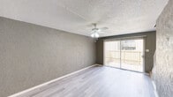 Located at 2900 S Fifth St in Garland, TX, this two-story home offers a practical and comfortable layout spread across two floors. The main level features a combined dining and living area with light wood-style flooring, a textured accent wall, and a ceiling fan with light fixture. Large sliding glass doors invite natural light and provide outdoor access. The kitchen is well-equipped with crisp white cabinetry, light countertops, a mosaic tile backsplash, a black electric range, a matching refrigerator, and a double sink positioned beneath a window. The adjacent dining area flows seamlessly from the kitchen, creating an open, connected feel. Both bathrooms feature wood-style flooring, with one showcasing a tub-shower combo framed by full-height tile surround and open built-in shelving nearby. Each of the two bedrooms includes a ceiling fan, textured walls in neutral tones, and vertical blind-covered windows that allow for adjustable natural light. The home is notably well-appointed with six closets distributed throughout, offering generous storage. Textured ceilings are consistent throughout the home, adding to its classic character. The two-floor design provides a clear separation between living and sleeping areas, enhancing the overall functionality of the space.