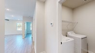 Located at 801 Shell Dr in Spring Lake, NC, this single-story home offers a thoughtfully designed layout across two bedrooms and two full bathrooms. The open-concept kitchen and living area serves as the heart of the home, showcasing white shaker cabinetry, granite countertops, a subway tile backsplash, stainless steel appliances, and a center island with pendant lighting — ideal for both everyday living and entertaining. A dedicated pantry closet provides additional storage directly off the kitchen. The dining area features a chandelier and an abundance of natural light through multiple windows and a glass door leading outdoors. Light wood-tone flooring flows consistently throughout the home, enhancing the bright, clean aesthetic. The primary bedroom is generously sized, featuring dual windows, a ceiling fan with recessed lighting, and access to a private en-suite bathroom with granite-topped dual vanity and a walk-in closet. The second bedroom includes a standard closet and a large window with outdoor views. A conveniently located utility room houses a full-size washer and dryer. Clean neutral walls, modern fixtures, and thoughtful storage solutions throughout give this home a fresh, move-in-ready appeal.