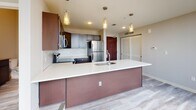 Located on Euclid Avenue in the heart of Cleveland, Ohio, this two-floor residence offers a thoughtfully designed living space with modern finishes and a clean, contemporary aesthetic throughout.

The kitchen serves as a central highlight, featuring a large island with a crisp white countertop, an undermount sink, and pendant lighting overhead. Dark espresso cabinetry is paired with stainless steel appliances — including a refrigerator, range, and over-the-range microwave — while a decorative arabesque tile backsplash adds a stylish touch. Light wood-look flooring runs throughout, contributing to a warm, cohesive feel.

The space includes multiple bathrooms finished with consistent attention to detail. One bathroom offers a dark-cabineted vanity with a neutral countertop, an undermount sink with brushed gold fixtures, and a large mirror. A second bathroom features a glass-enclosed walk-in shower with large-format marble-style tile, a matching dark vanity, and chrome hardware — combining elegance with functionality.

The overall layout across two floors provides separation between living and private areas, making the space both practical and comfortable. Neutral wall tones, recessed lighting, and wood-look flooring unify the design, creating a modern and inviting atmosphere suited for everyday living in a vibrant urban setting.