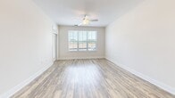 Located at 410 Redbud Ridge Dr in Knightdale, NC, this well-appointed one-bedroom, one-bathroom residence offers a thoughtfully designed single-floor layout. The open-concept kitchen and living area serves as the heart of the home, featuring warm wood-style luxury vinyl plank flooring that flows throughout the main living spaces. The kitchen is equipped with stainless steel appliances — including a refrigerator with ice maker, range, over-the-range microwave, and dishwasher — complemented by grey shaker-style cabinetry, a white subway tile backsplash, and a granite-topped island that provides additional prep and dining space. Large windows in the living area allow abundant natural light to pour in, while a ceiling fan adds comfort. The bedroom is carpeted and bright, with window blinds offering privacy and views of the surrounding area. A dedicated closet provides ample storage. The bathroom impresses with a dual-sink vanity topped in granite, grey shaker cabinetry with brushed nickel hardware, large mirrors, and matching wood-style flooring, creating a clean and cohesive aesthetic. The overall design palette — neutral tones, modern finishes, and consistent materials — gives the entire space a fresh, move-in-ready feel.