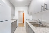 Located at 183 Berry Rd in Toronto's Mimico neighbourhood, this well-appointed one-bedroom, one-bathroom unit offers a clean, modern aesthetic across a thoughtfully laid-out single floor. Light wood laminate flooring runs throughout the living spaces, lending warmth and continuity to the interior.

The spacious living room is a standout feature, bathed in natural light streaming through a large picture window that frames views of the surrounding greenery. A white radiator beneath the window provides efficient heating, complementing the room's bright, airy feel.

The galley-style kitchen is efficiently designed with two parallel runs of cabinetry finished in soft grey, topped with speckled granite-look countertops. A stainless steel sink, electric range, and full-size white refrigerator provide all essential appliances, while a window at the end of the kitchen draws in additional natural light.

The bedroom is a comfortably sized retreat with light wood flooring, neutral walls, a window with outdoor views, and a dedicated closet. The clean, minimalist palette makes the space feel open and versatile.

The bathroom is finished with bright white subway-style wall tiles surrounding a full tub and shower combo, accented with chrome fixtures for a crisp, timeless look. Overall, the unit presents a cohesive, light-filled living environment well-suited to comfortable urban living.