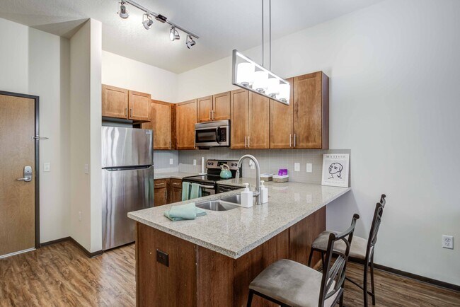 Apartamentos Dinkytown en The Knoll, cerca de la Universidad de Minnesota, con cocina con isla extra ancha, taburetes y encimeras de granito. - The Knoll Dinkytown