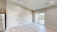 Located at 19448 Northridge Dr in Northville, MI, this thoughtfully designed 2-bedroom, 2-bathroom unit offers a clean, modern aesthetic throughout its single-floor layout. Light wood-tone luxury vinyl plank flooring flows through the open-concept living, dining, and kitchen area, complemented by neutral warm-gray walls, recessed lighting, and crisp white trim. The living space features sliding glass doors that open to a private balcony with outdoor views, filling the room with natural light. The kitchen is outfitted with light wood cabinetry, a white subway tile backsplash, quartz-style countertops, and a full suite of stainless steel appliances including a refrigerator, range, microwave, and dishwasher. A central hallway connects the main living area to both bedrooms, each featuring plush carpeting, generous closet space with stylish barn-style or double-panel doors, and ample room for furnishings. The primary bedroom includes its own en-suite bathroom with a walk-in shower, wood-toned vanity, and brushed nickel fixtures. The second bathroom offers a full tub-shower combination with matching finishes. An in-unit laundry area and four closets provide exceptional storage throughout. The overall ambiance is bright, fresh, and move-in ready.