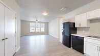 This contemporary 1160 square foot apartment offers a well-designed living space with three bedrooms and two bathrooms. The open floor plan seamlessly integrates the kitchen and living areas, creating an inviting atmosphere for both daily life and entertaining. The kitchen boasts sleek white cabinetry, contrasting black appliances, and light wood-tone flooring, providing a modern and functional cooking space.

Each bedroom is generously sized, with the primary bedroom measuring 170 square feet. Plush carpeting in the bedrooms adds comfort underfoot, while ceiling fans ensure good air circulation. Large windows throughout allow for abundant natural light and offer views of the surrounding area.

The bathrooms feature clean lines with white fixtures, including a shower-tub combination and ample storage space. The apartment's neutral color palette, predominantly in whites and light grays, creates a bright and airy feel throughout.

Additional amenities include a walk-in closet with wire shelving systems for optimal organization. The unit's single floor layout enhances accessibility and ease of movement. Located in Bettendorf, Iowa, this apartment combines urban convenience with comfortable living, making it an attractive option for a variety of lifestyles.