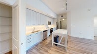 Located in Royal Palm Beach, FL, this thoughtfully designed single-floor residence offers three bedrooms and two bathrooms within a well-organized, efficiently utilized layout. The open-concept kitchen and living area serves as the heart of the home, featuring light wood-style flooring, high ceilings, and an abundance of natural light. The kitchen is outfitted with sleek, light-toned flat-panel cabinetry, a subway tile backsplash, stainless steel appliances including a range, microwave, dishwasher, and French door refrigerator, plus a white center island ideal for dining or food preparation. The living area extends to a sliding glass door with vertical blinds, opening to an outdoor balcony view and enhanced by a ceiling fan overhead. The bedrooms are carpeted for comfort, with the primary bedroom offering a spacious walk-in closet with built-in shelving. Secondary bedrooms feature large windows with blinds that invite natural light and exterior views of the surrounding landscape. The two bathrooms are finished with wood-look tile flooring, modern floating vanities with white countertops, illuminated mirrors, and clean white walls. A connecting hallway ties all rooms together seamlessly, completing this well-appointed and move-in ready residence.