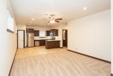 Located at 19 Idlewood Ln in Canyon, TX, this single-story home offers a well-designed open-concept layout that seamlessly connects the kitchen and living areas. The kitchen is a standout feature, equipped with rich dark wood cabinetry, granite countertops, a subway tile backsplash, and a full suite of stainless steel appliances including a gas range, built-in microwave, dishwasher, and refrigerator. A central island provides additional prep space and casual dining options. Large-format tile flooring runs throughout the kitchen and utility areas, while plush carpet covers the living and bedroom spaces, adding warmth and comfort.

The living area is generously sized, featuring recessed lighting and a ceiling fan for year-round comfort. Bedrooms are bright and neutral, each with carpeted floors, natural light from windows with blinds, and dark baseboards that complement the home's consistent design palette. The bathrooms are finished with dark wood vanities, white countertops, and tub-shower combinations with windows for natural light. A dedicated laundry room includes upper cabinetry, washer/dryer hookups, and an electrical panel, adding practical functionality to the home.